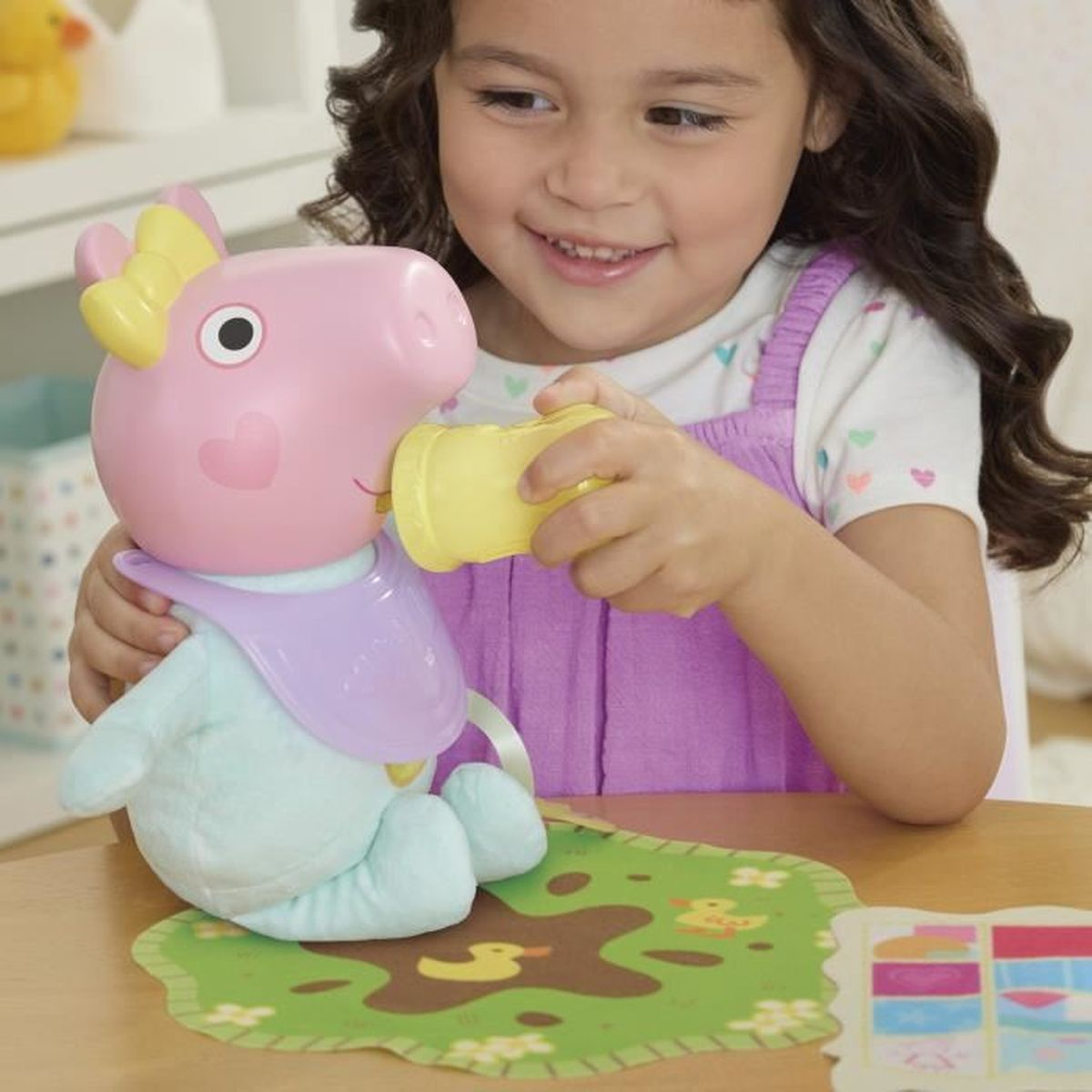 Ein Mädchen füttert eine Peppa Wutz-Puppe mit einer gelben Flasche.
