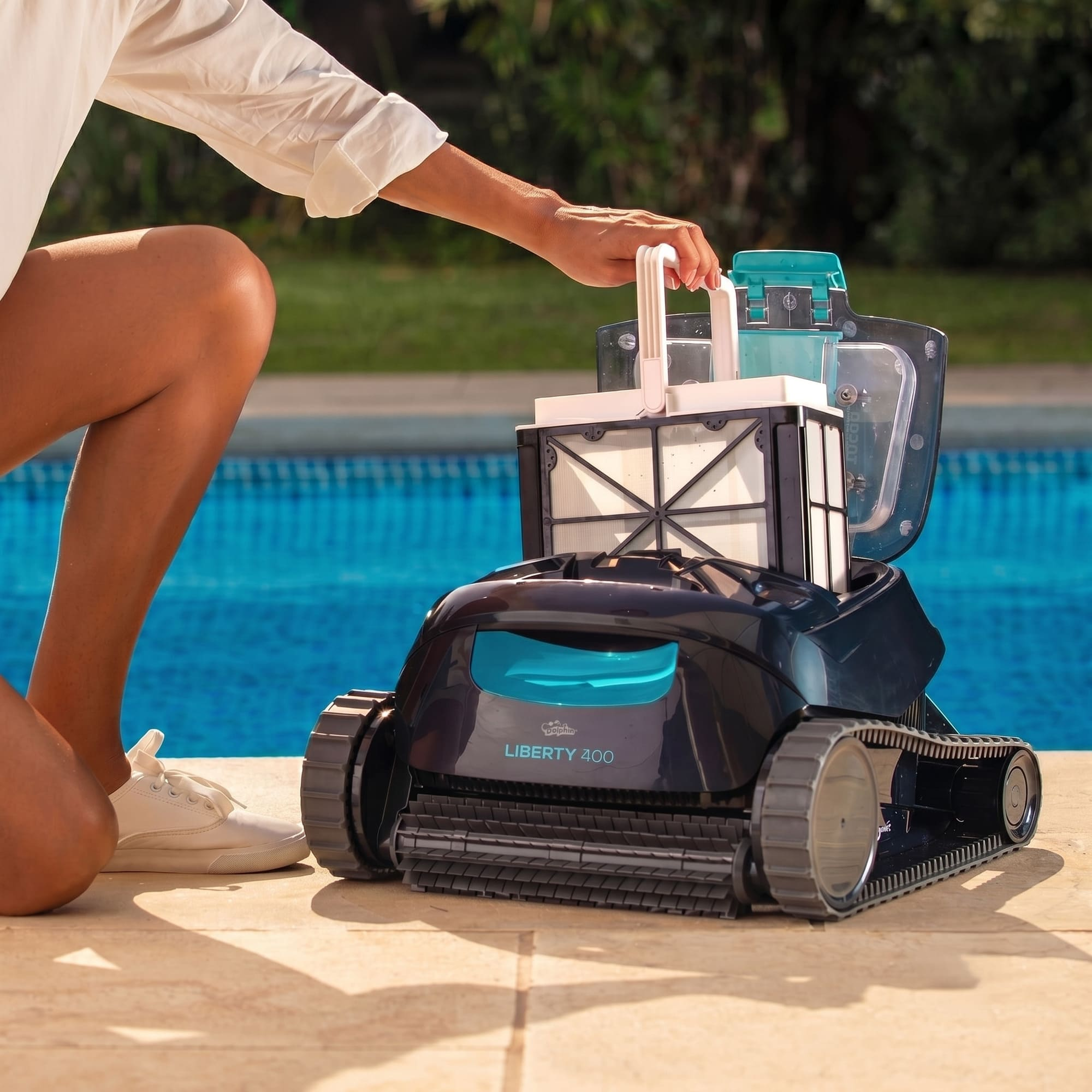 Una persona saca un robot de piscina con filtros del agua.