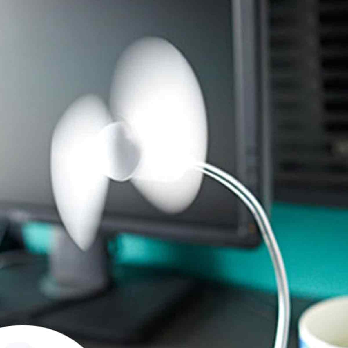 Ein kleiner weißer Ventilator dreht sich vor einem dunklen Computerbildschirm.