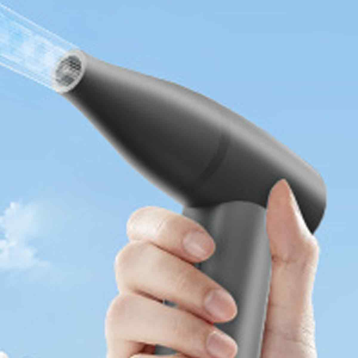 Eine Hand hält einen schwarzen Haartrockner, aus dem blauer Dampf kommt.
