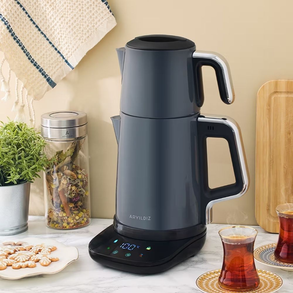 Cam kavanoz, kurabiye ve iki çay bardağı ile gri çay makinesi seti.