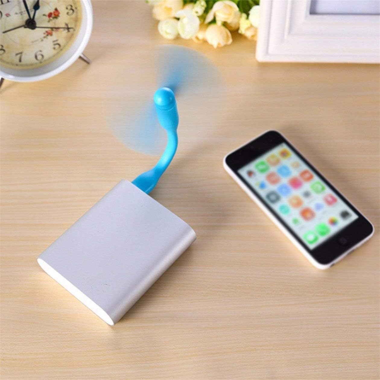 Ein kleiner USB-Ventilator ist an einem silbernen Akku befestigt, daneben liegt ein Smartphone.