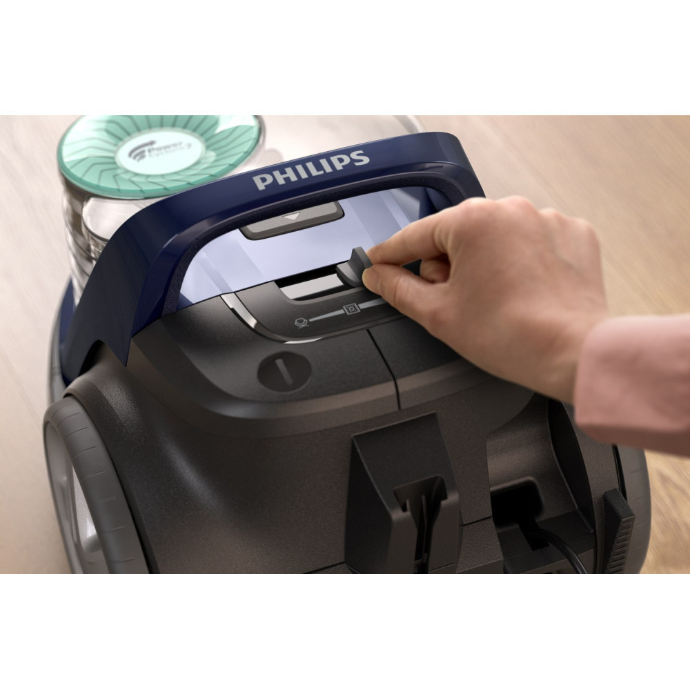 Mano che aziona un interruttore su un aspirapolvere Philips con coperchio blu.
