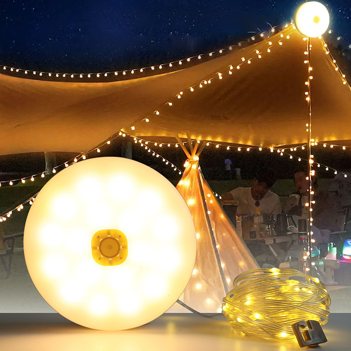 Eine runde Lampe und Lichterkette unter einem Zelt bei Nacht.