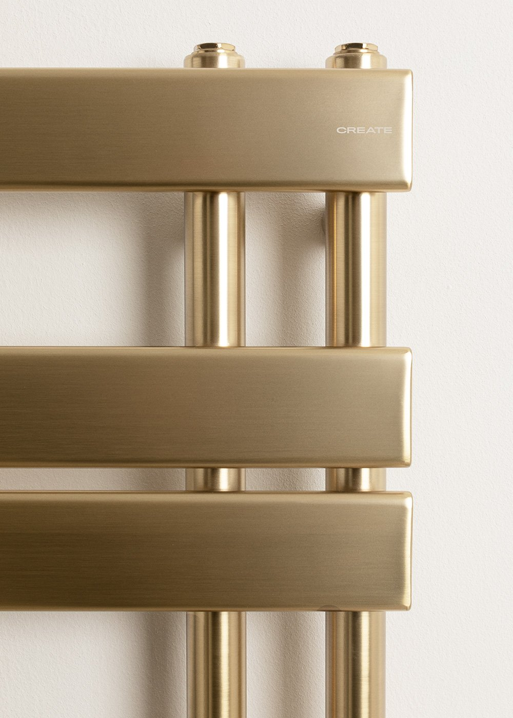 Radiador dorado con barras horizontales y soportes verticales. Texto: CREATE.