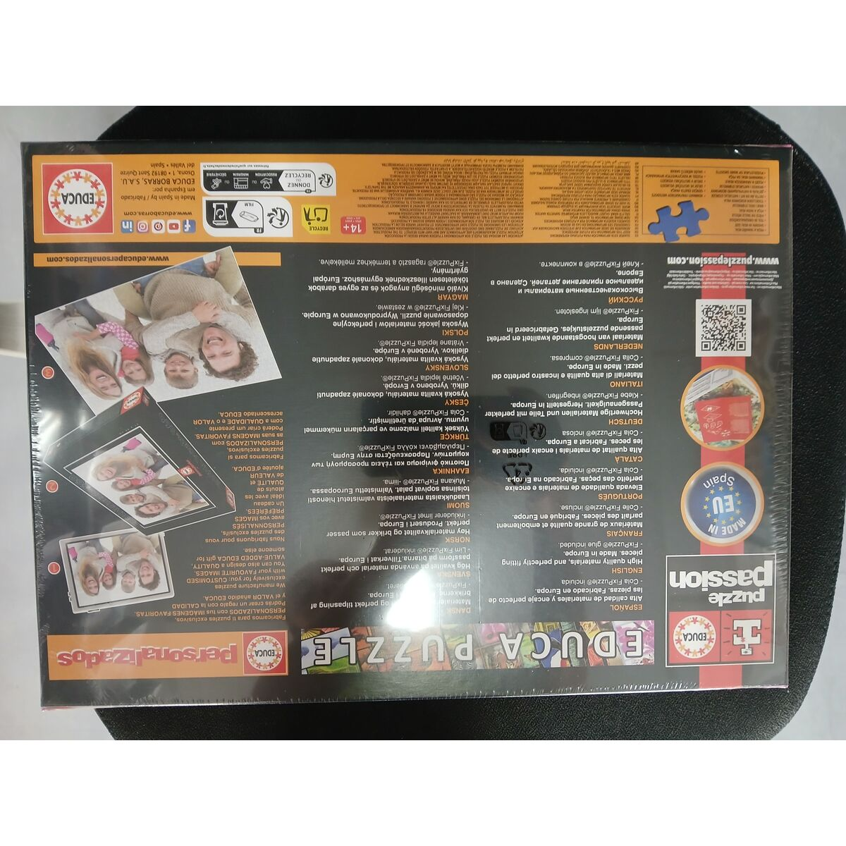Embalaje de puzzle con una familia en el frente y texto en varios idiomas.