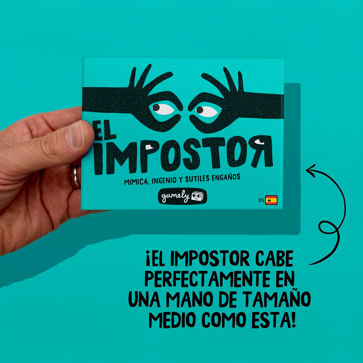 Una mano sostiene una caja de juego turquesa con ojos y manos negras.