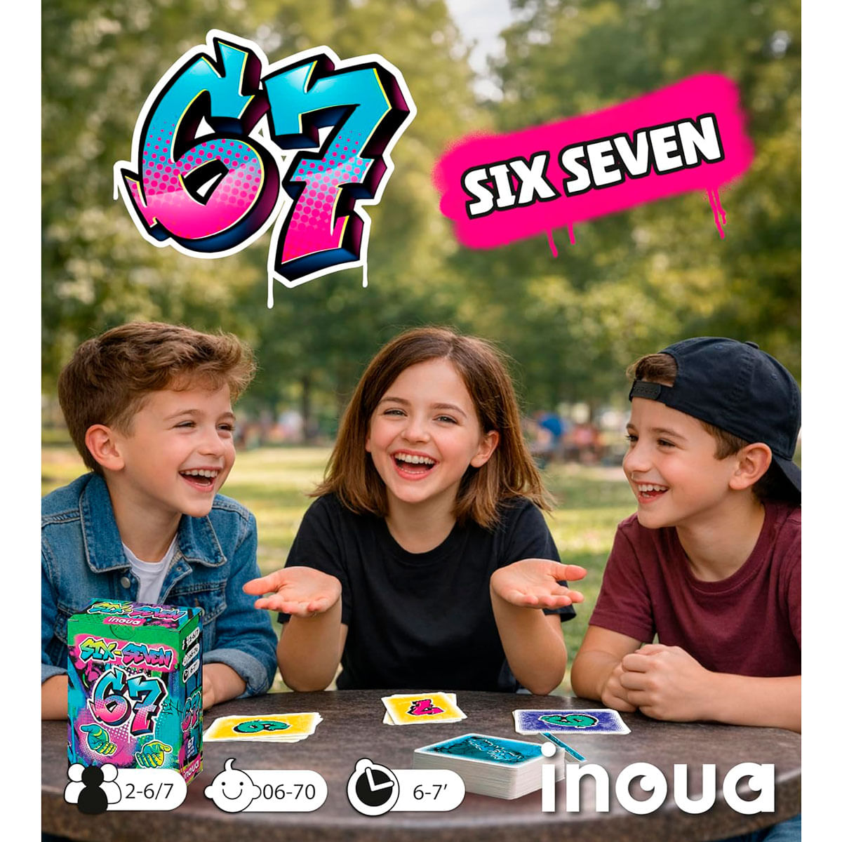 Tres niños sonrientes jugando a un juego de cartas al aire libre con la caja y cartas sobre la mesa.