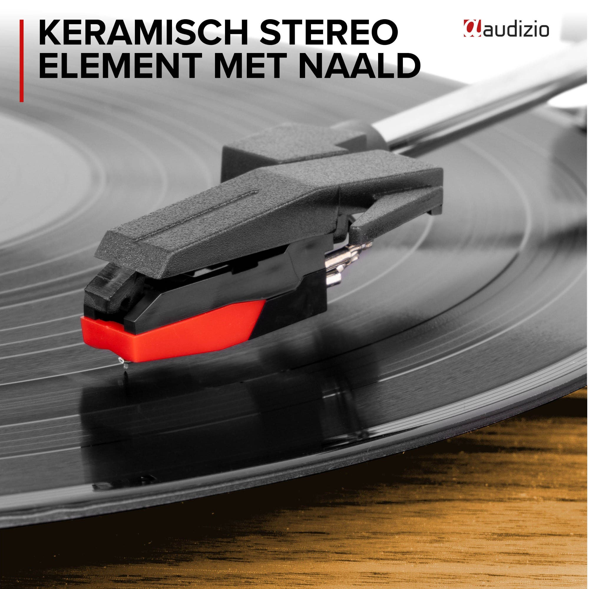 A turntable cartridge with red and black casing on a vinyl record.
