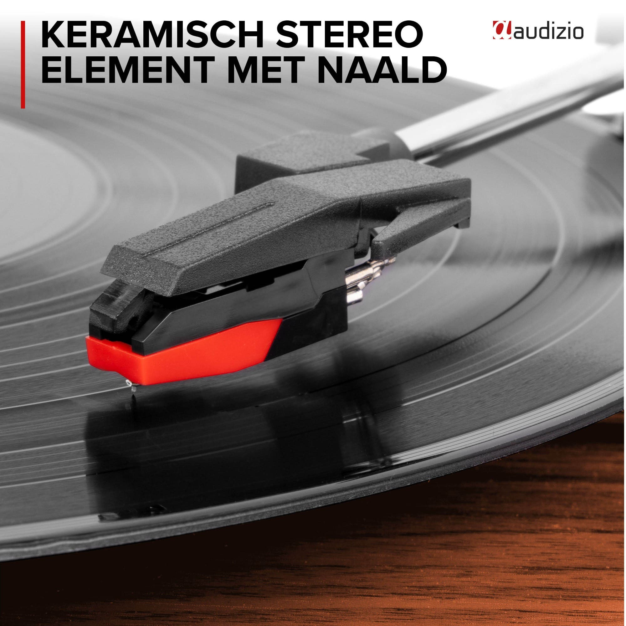 A record player stylus with a red tip on a vinyl record.