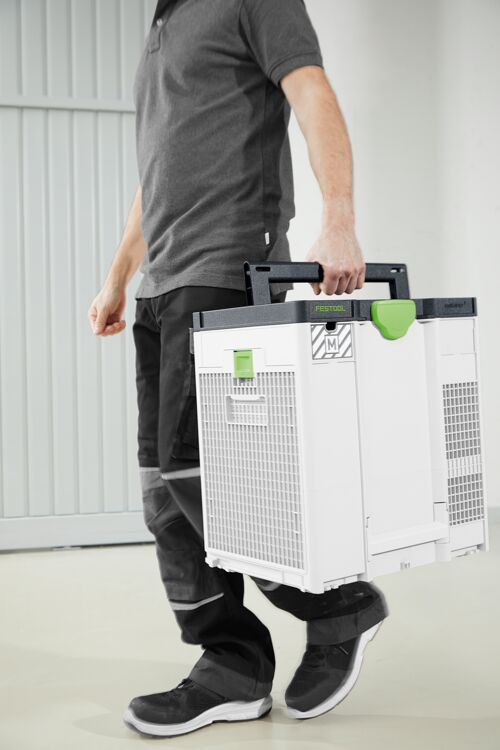 Uomo porta cassetta attrezzi bianca con manico verde davanti porta garage.