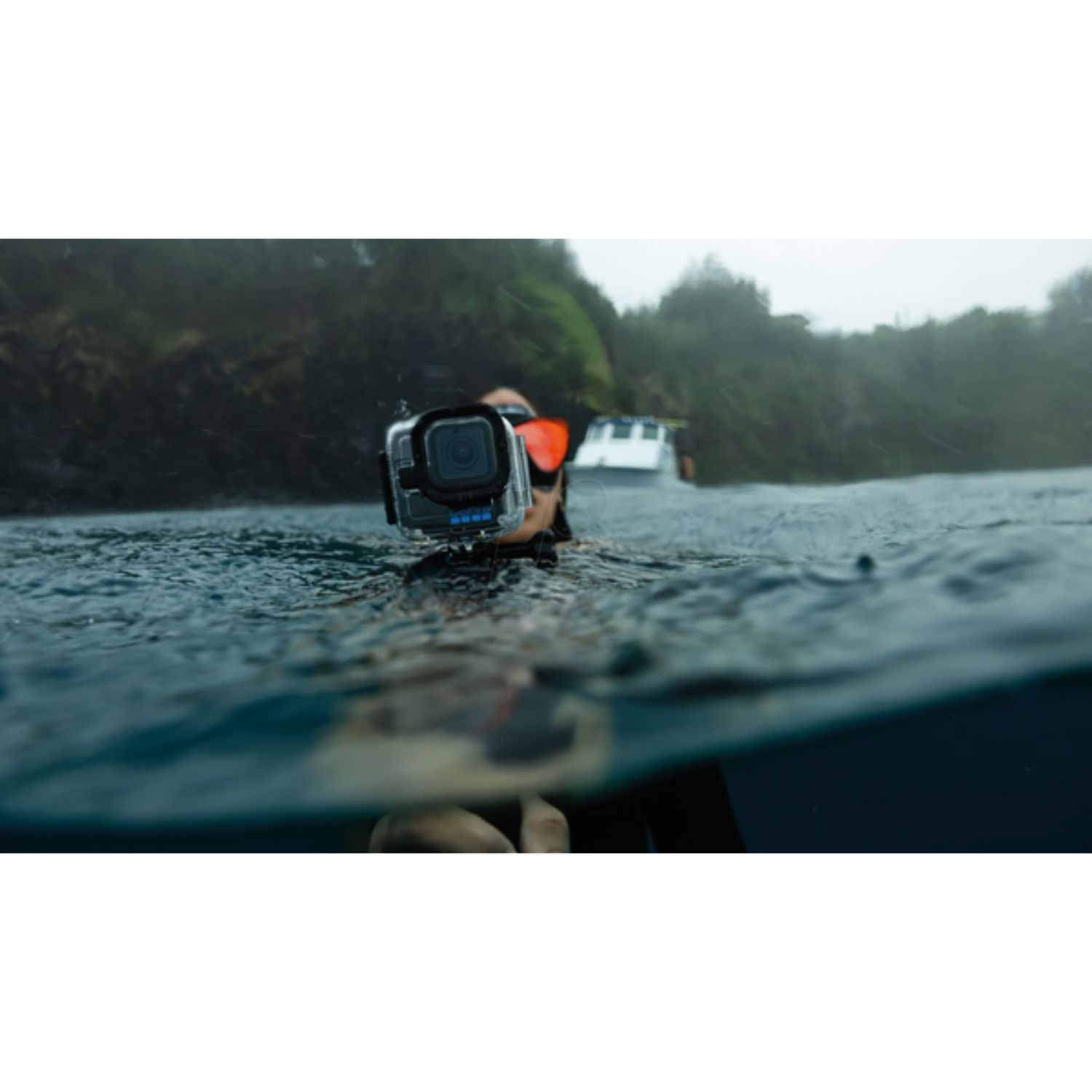 Eine Person schwimmt im Meer mit einer GoPro-Kamera und Schnorchelausrüstung.