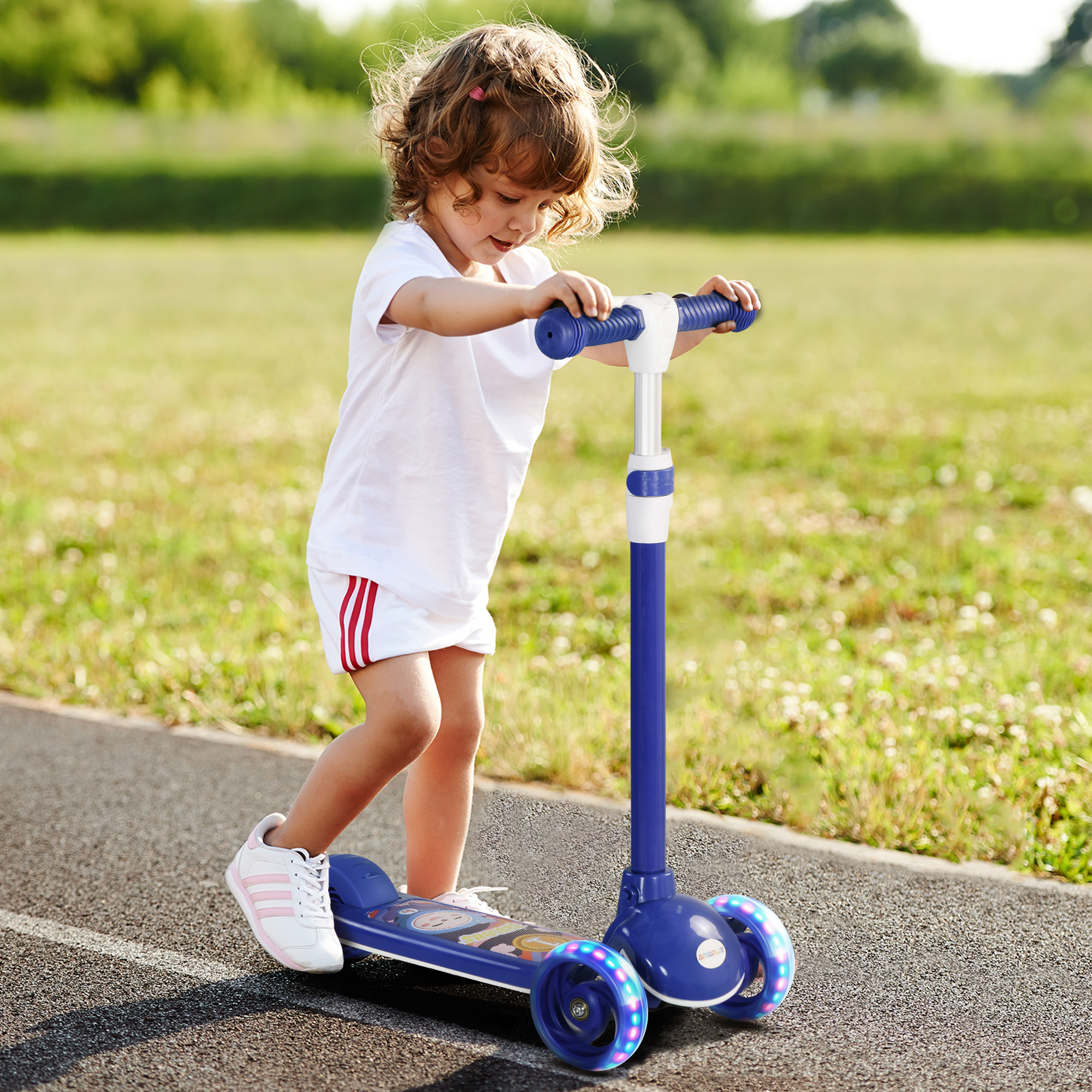 Una niña pequeña monta un patinete azul de tres ruedas con ruedas luminosas en una pista.