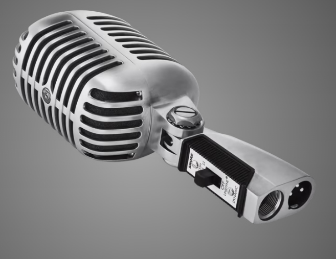 Un micrófono plateado vintage con interruptor y conectores XLR sobre fondo gris.