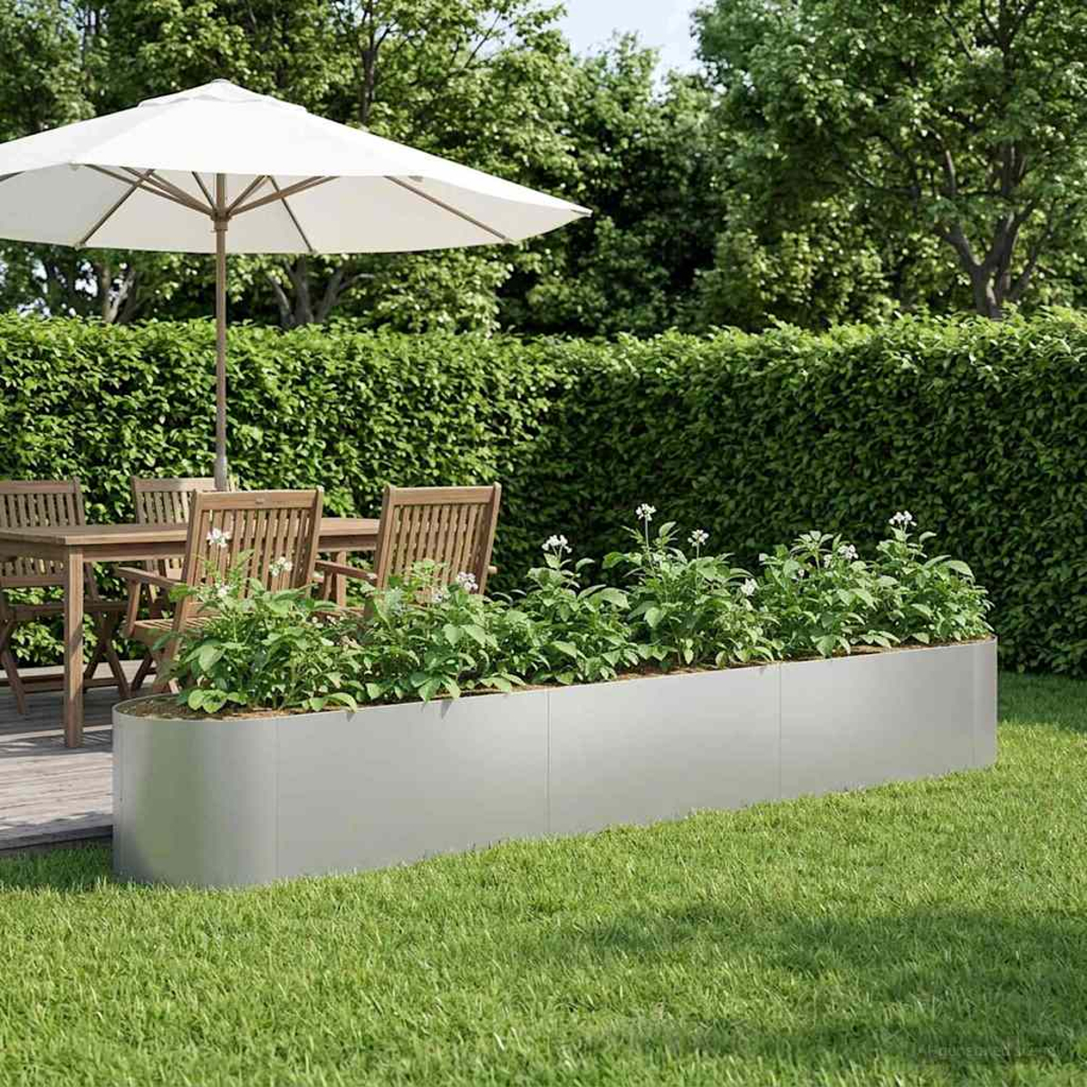 Außenpatio mit Holztisch, Stühlen, Sonnenschirm und einem langen Pflanzkasten mit Pflanzen.