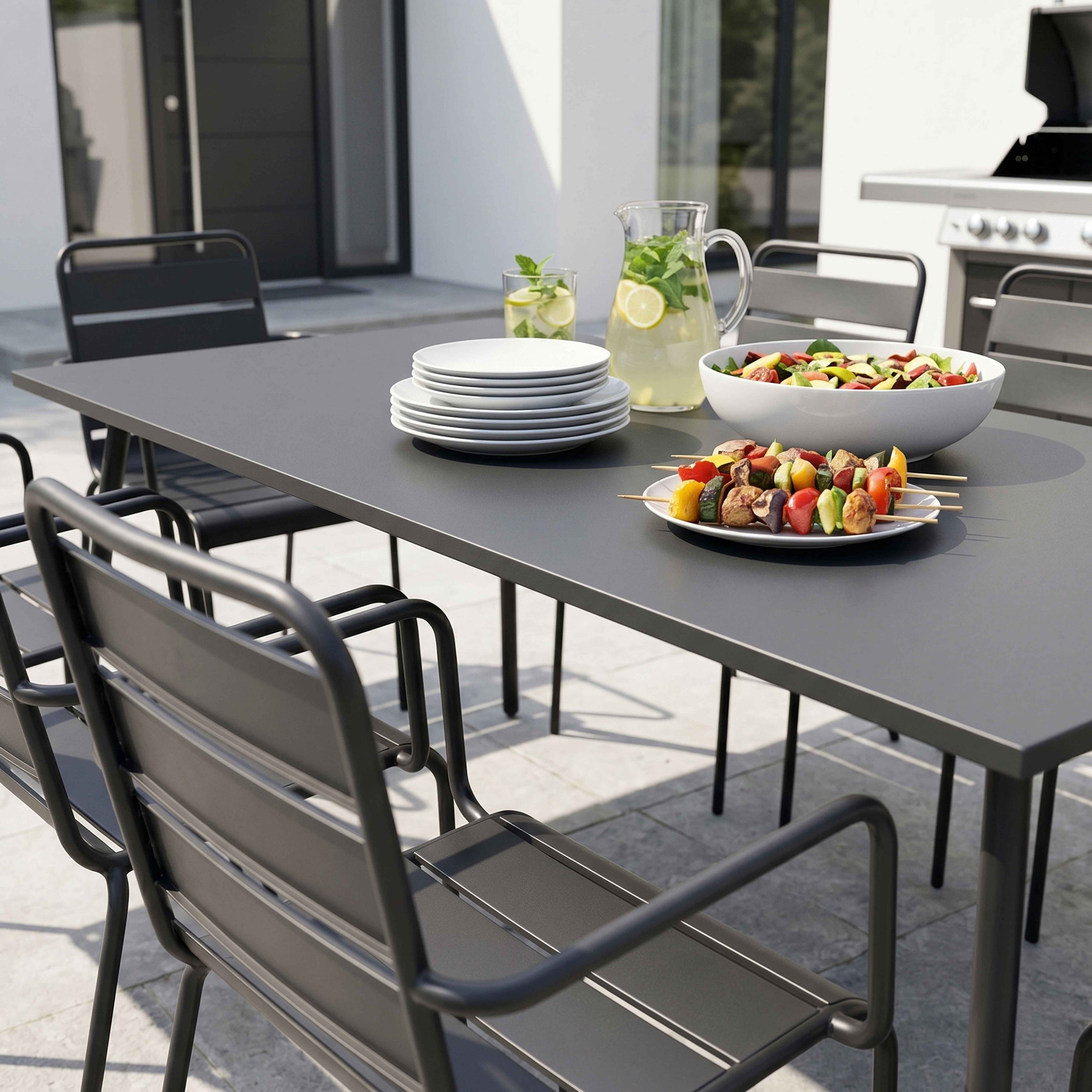 Ein Gartentisch mit Essen, Getränken und Grill im Freien.