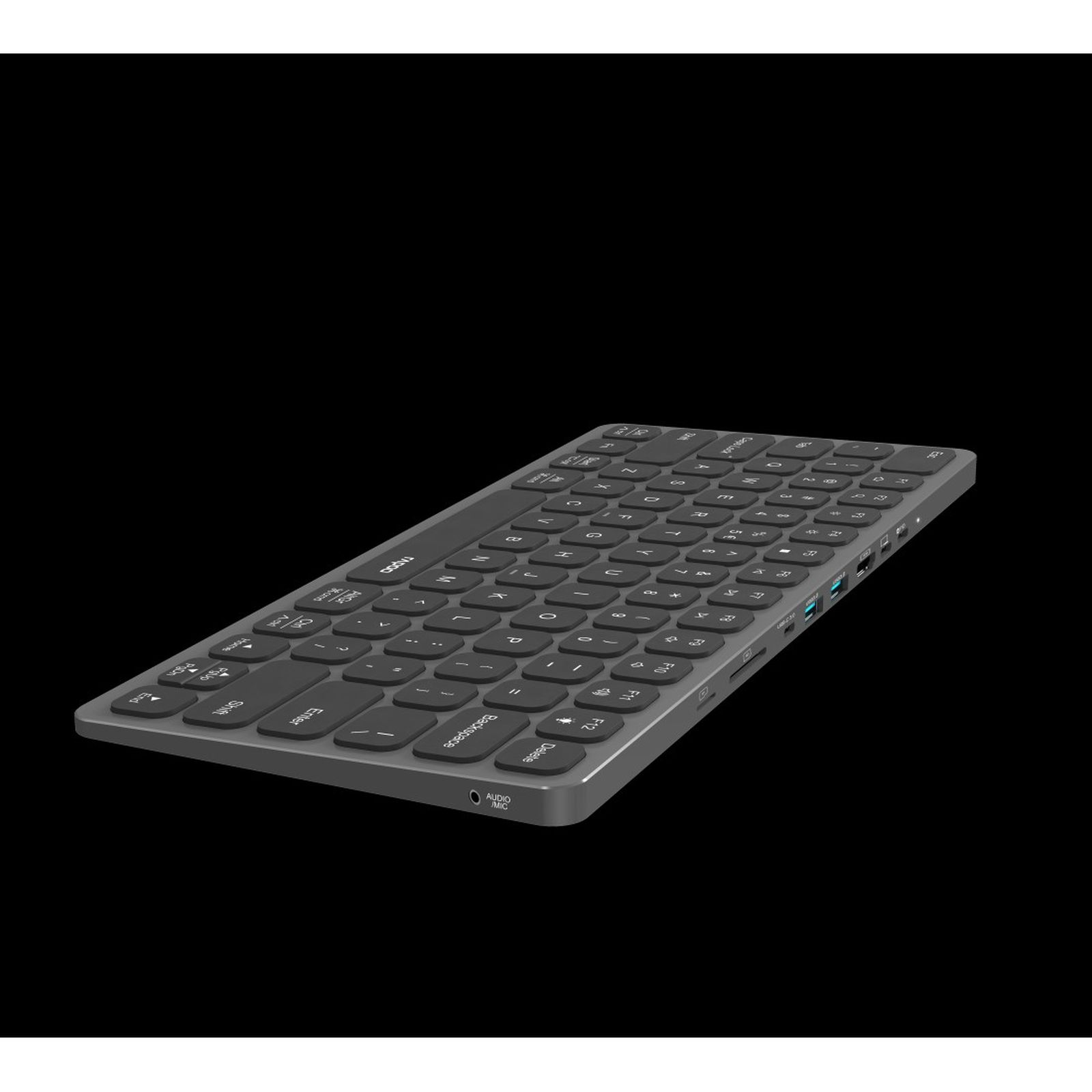Teclado gris con puertos USB y conector de audio, aislado sobre fondo negro.