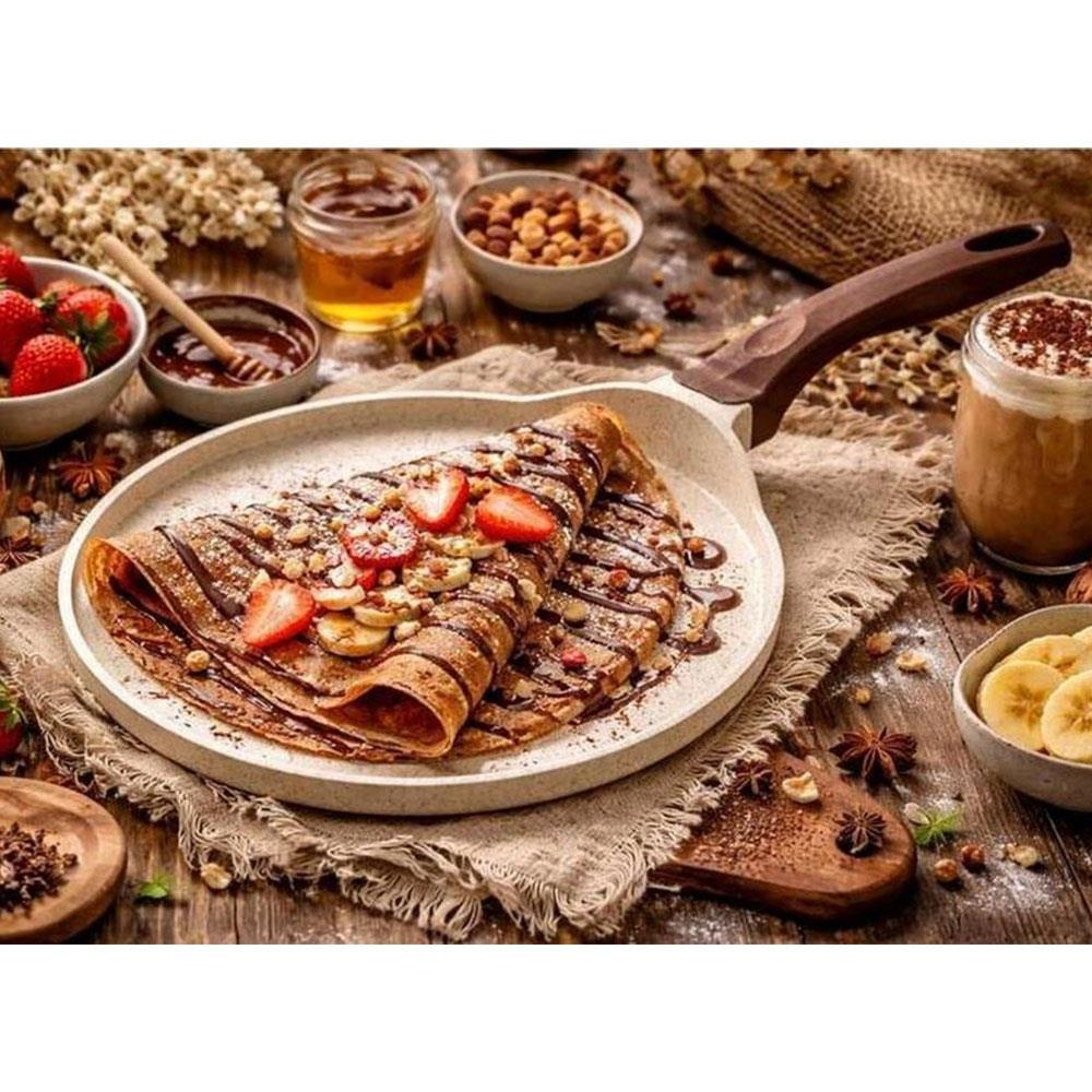 Çikolata soslu, çilekli, muzlu krep bir tabakta servis ediliyor.