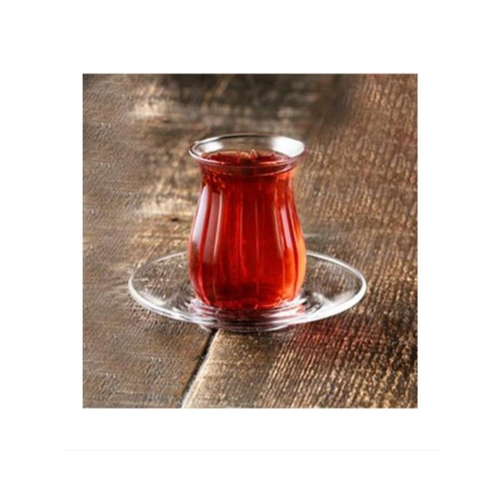 Ahşap zeminde cam tabakta kırmızı çay bardağı.