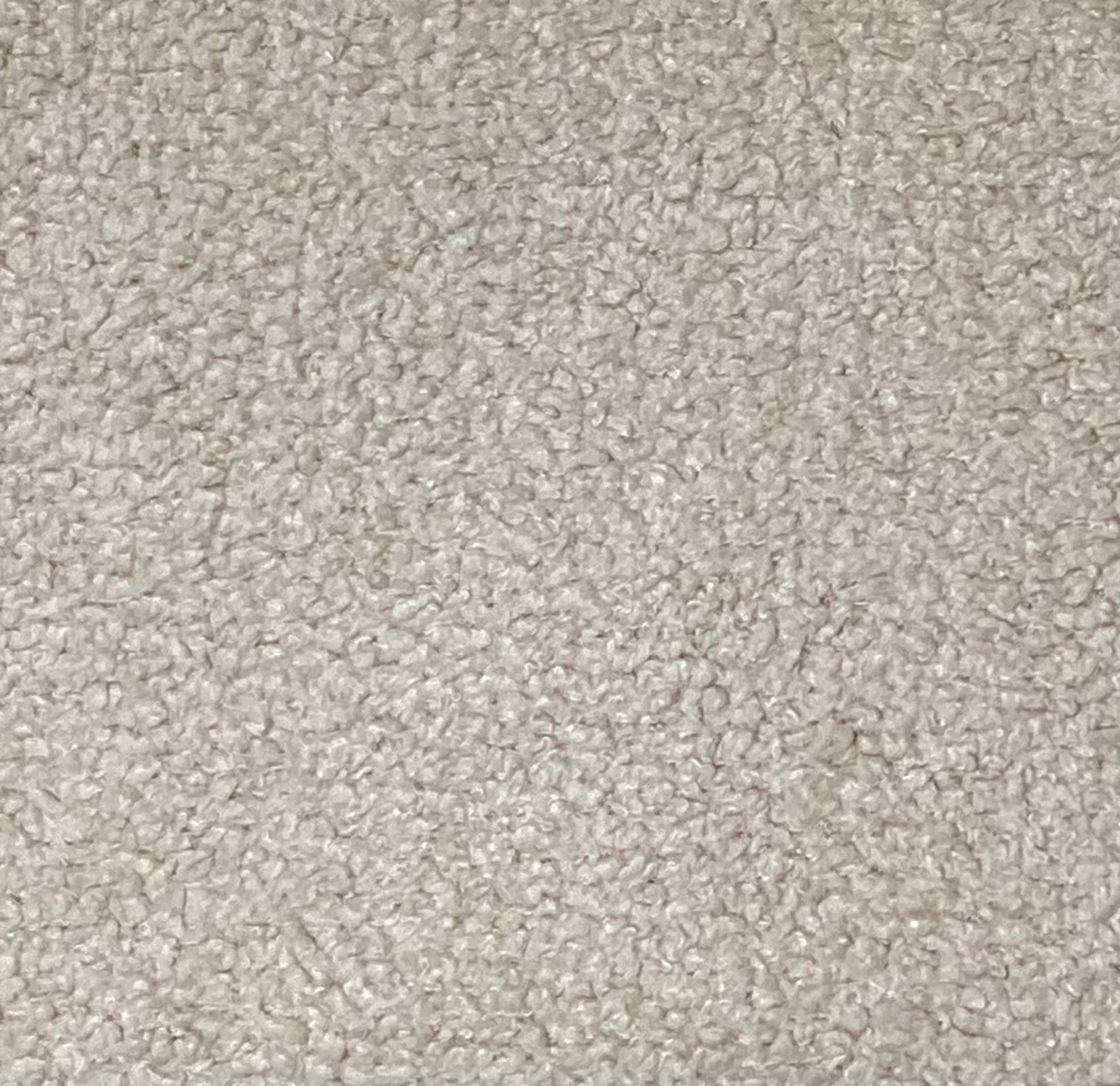 Un primer plano de tela de oso de peluche beige con textura rizada.