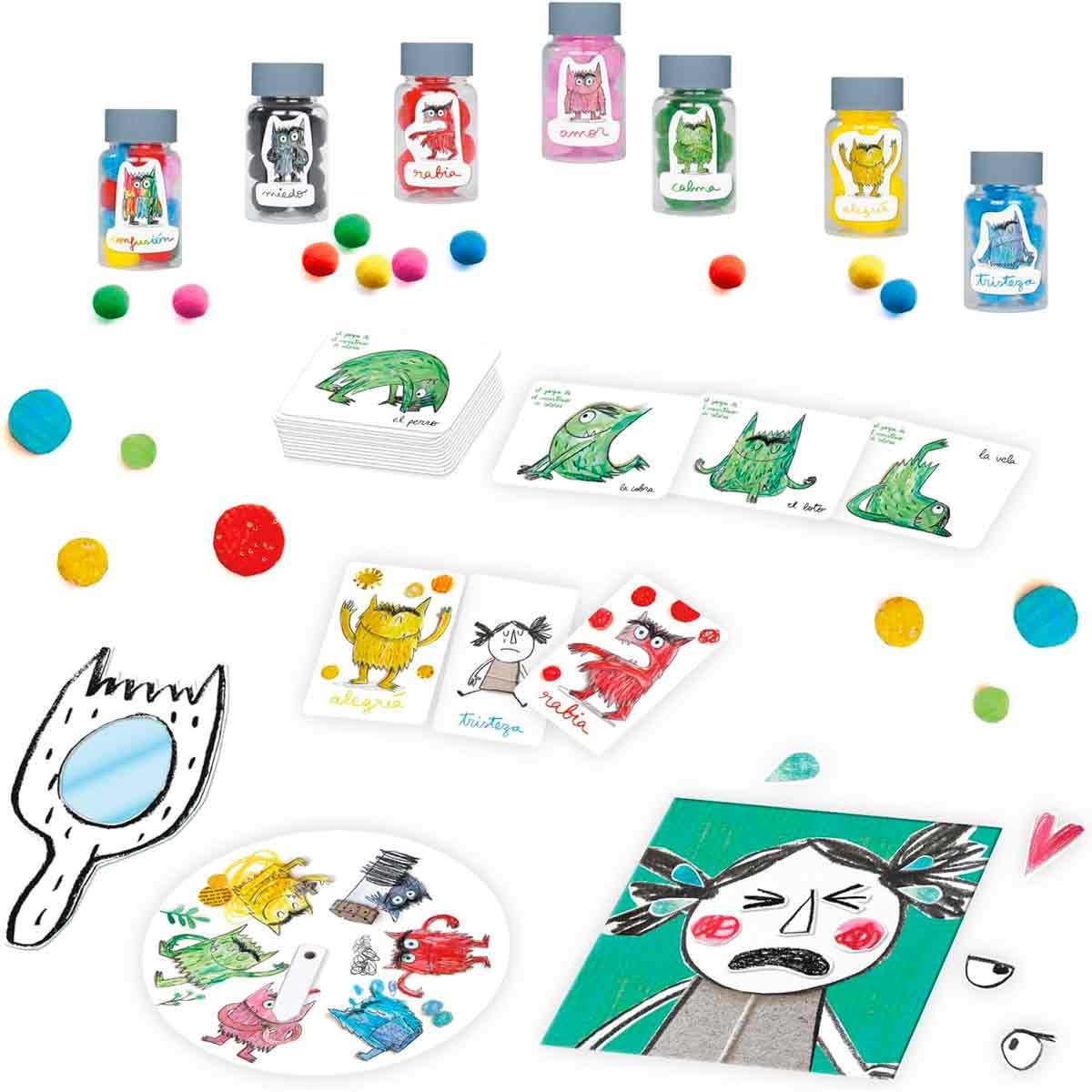 Juguetes variados y coloridos con monstruos, cartas y pompones sobre fondo blanco.