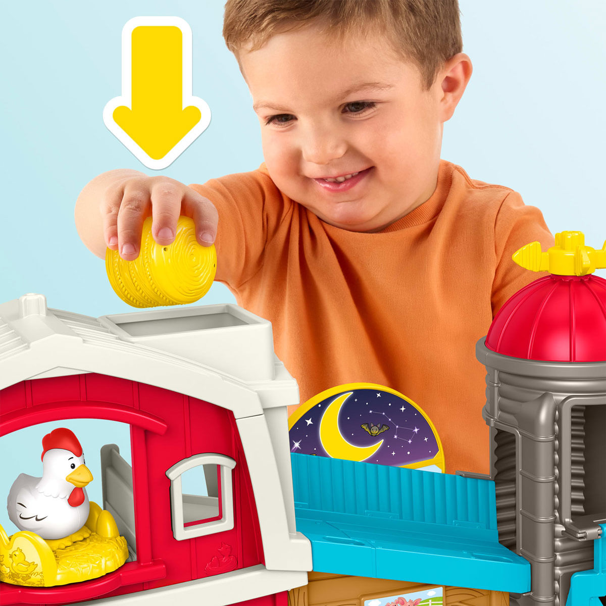 Un niño juega con un juego de granja de juguete con una gallina blanca.
