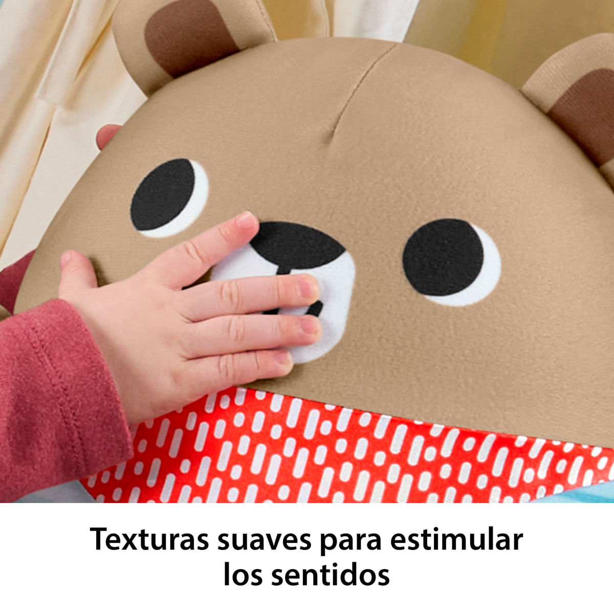 La mano de un bebé toca un peluche de oso marrón con puntos rojos.