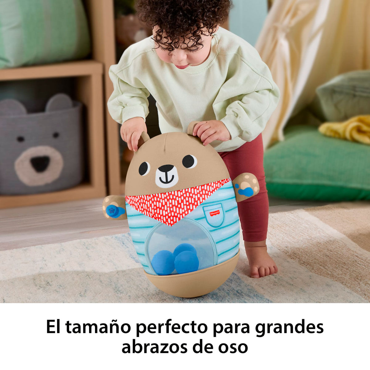 Un niño pequeño juega con un juguete con forma de oso que contiene pelotas azules.