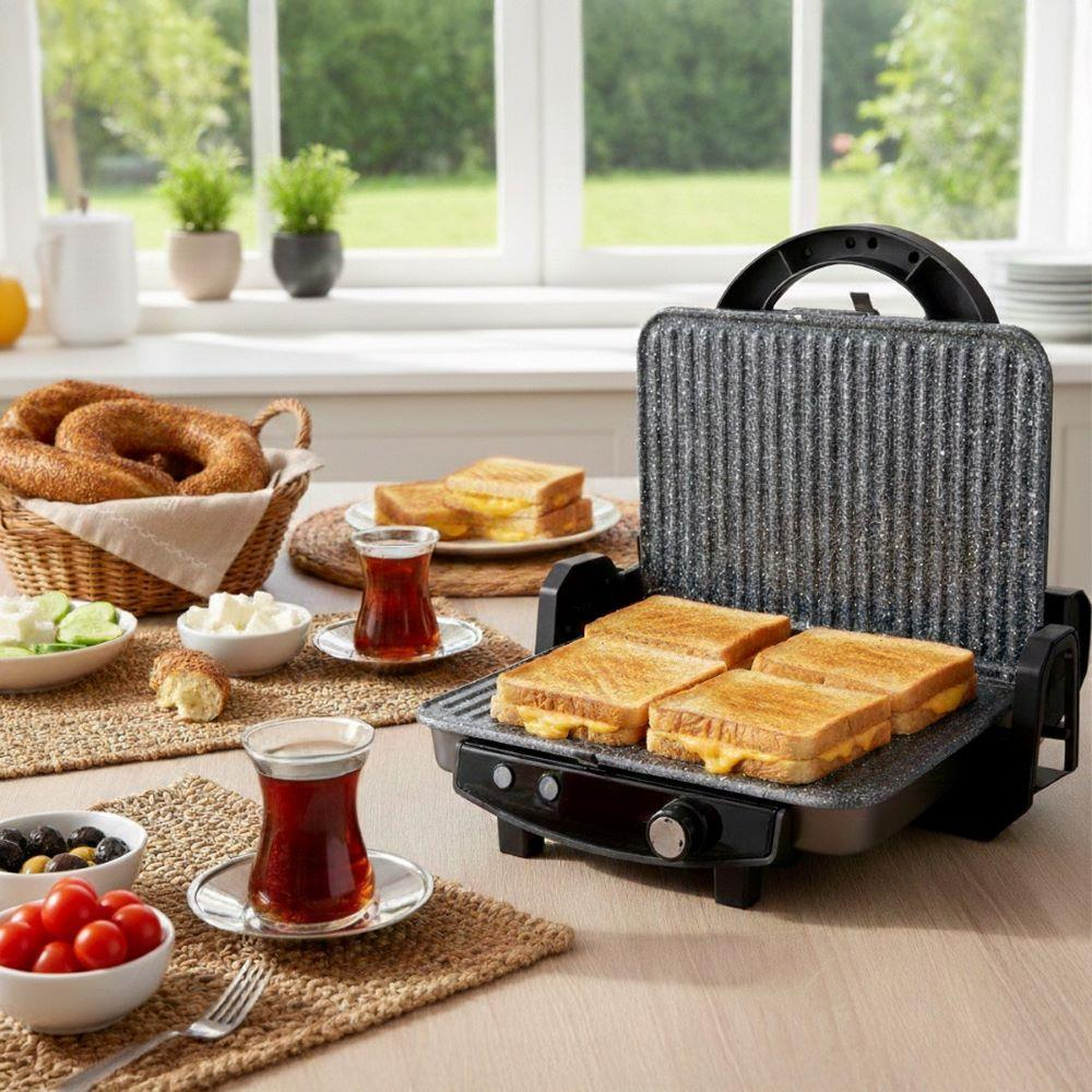 Dört sandviçli grill tost makinesi, simit sepeti, zeytin, domates ve çay.