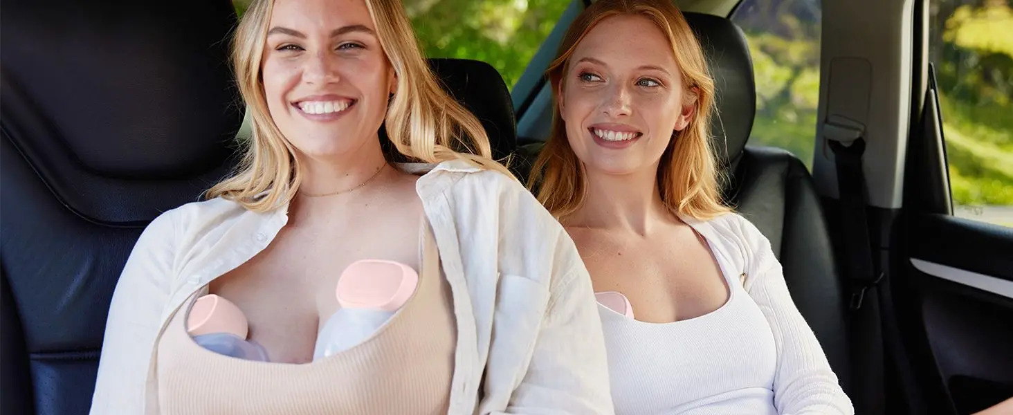 Due donne sorridenti in auto, entrambe con tiralatte.