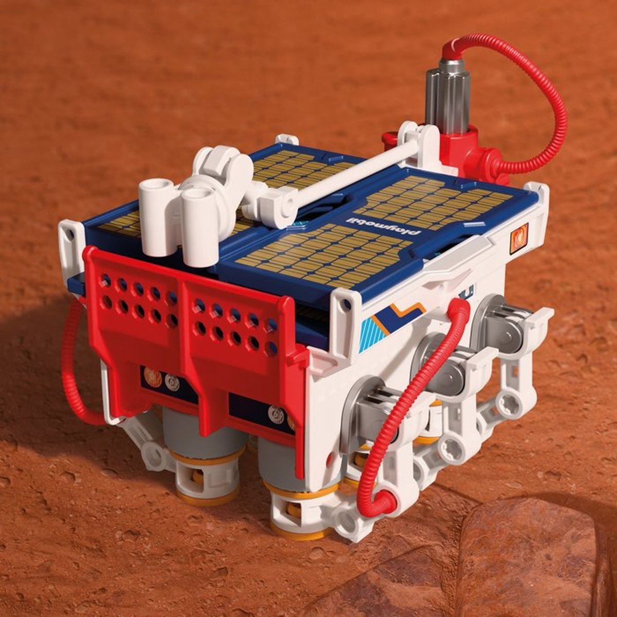 Un rover de juguete blanco y rojo con paneles solares sobre una superficie arenosa.
