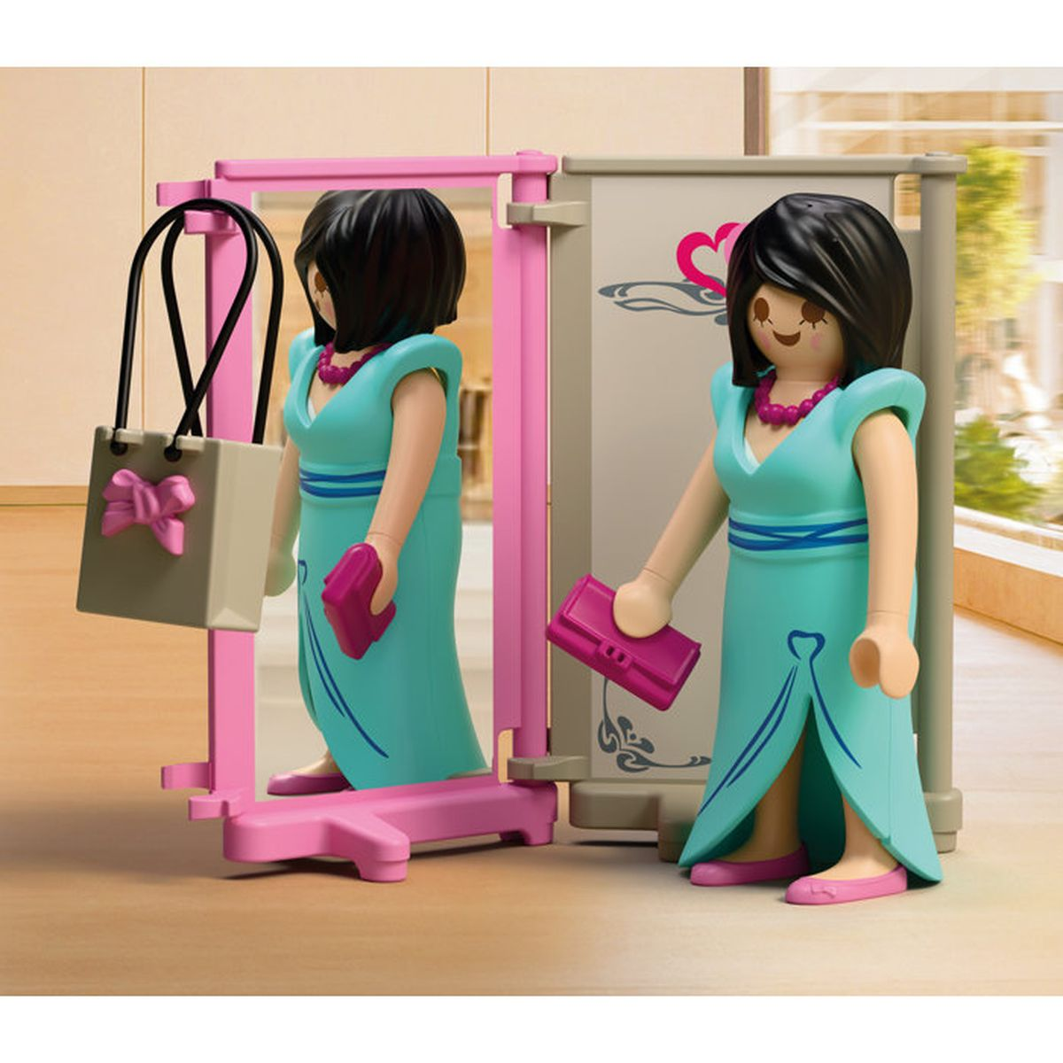 Figura con vestido turquesa y bolso delante de espejo y soporte.