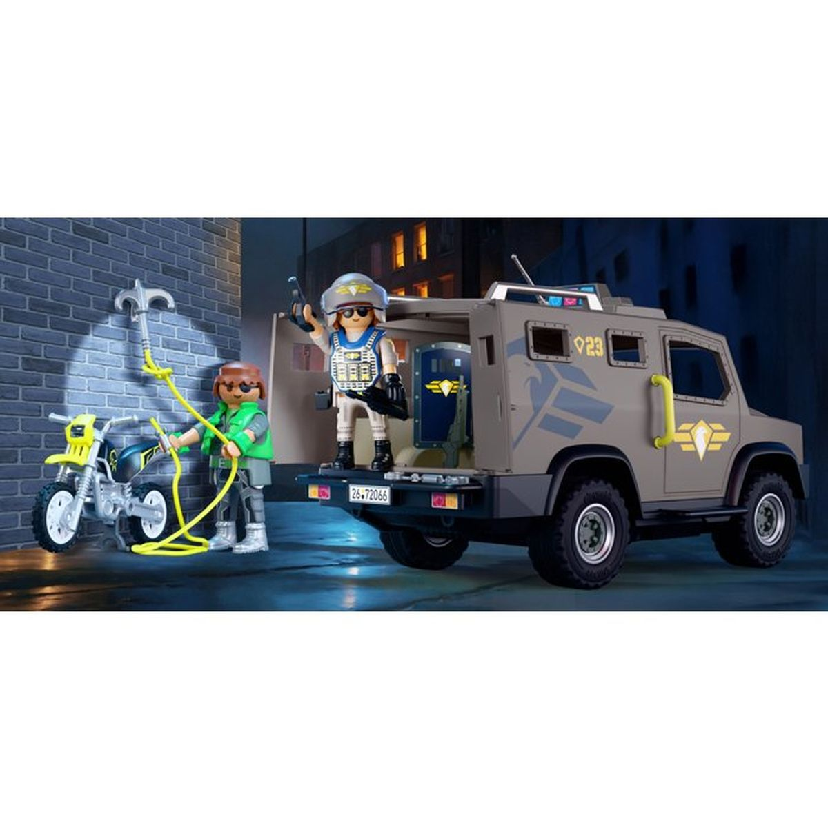 Un vehículo blindado con dos figuras de Playmobil y una motocicleta frente a una pared de ladrillos.
