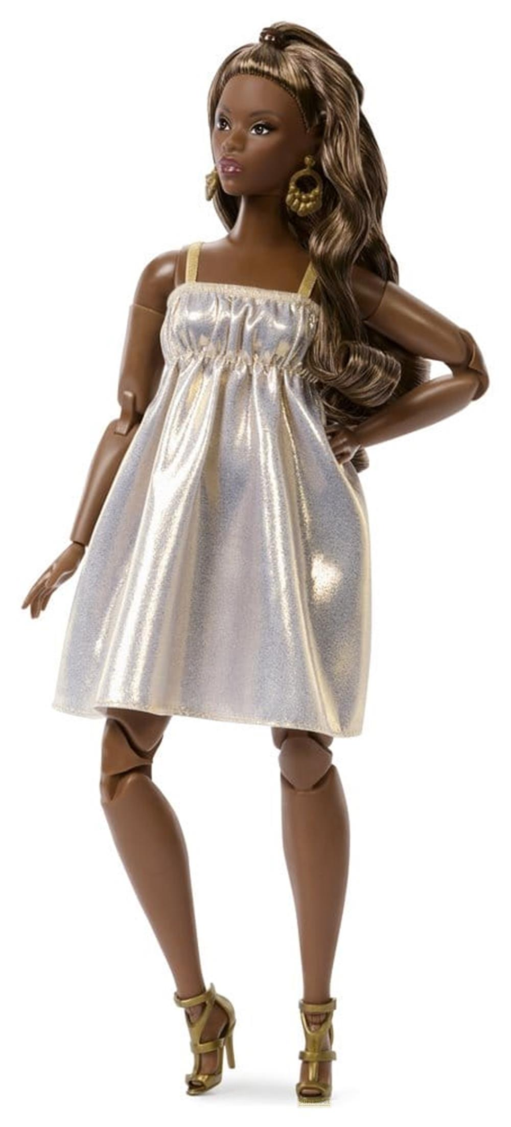 Una muñeca de piel oscura y cabello castaño largo lleva un vestido plateado brillante.