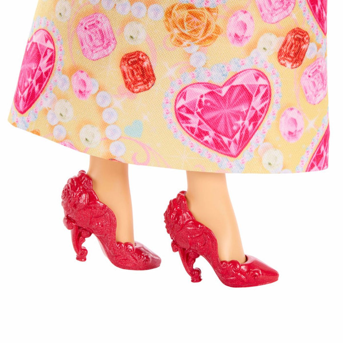 Primer plano de pies de muñeca con zapatos rojos y falda con estampado de joyas.