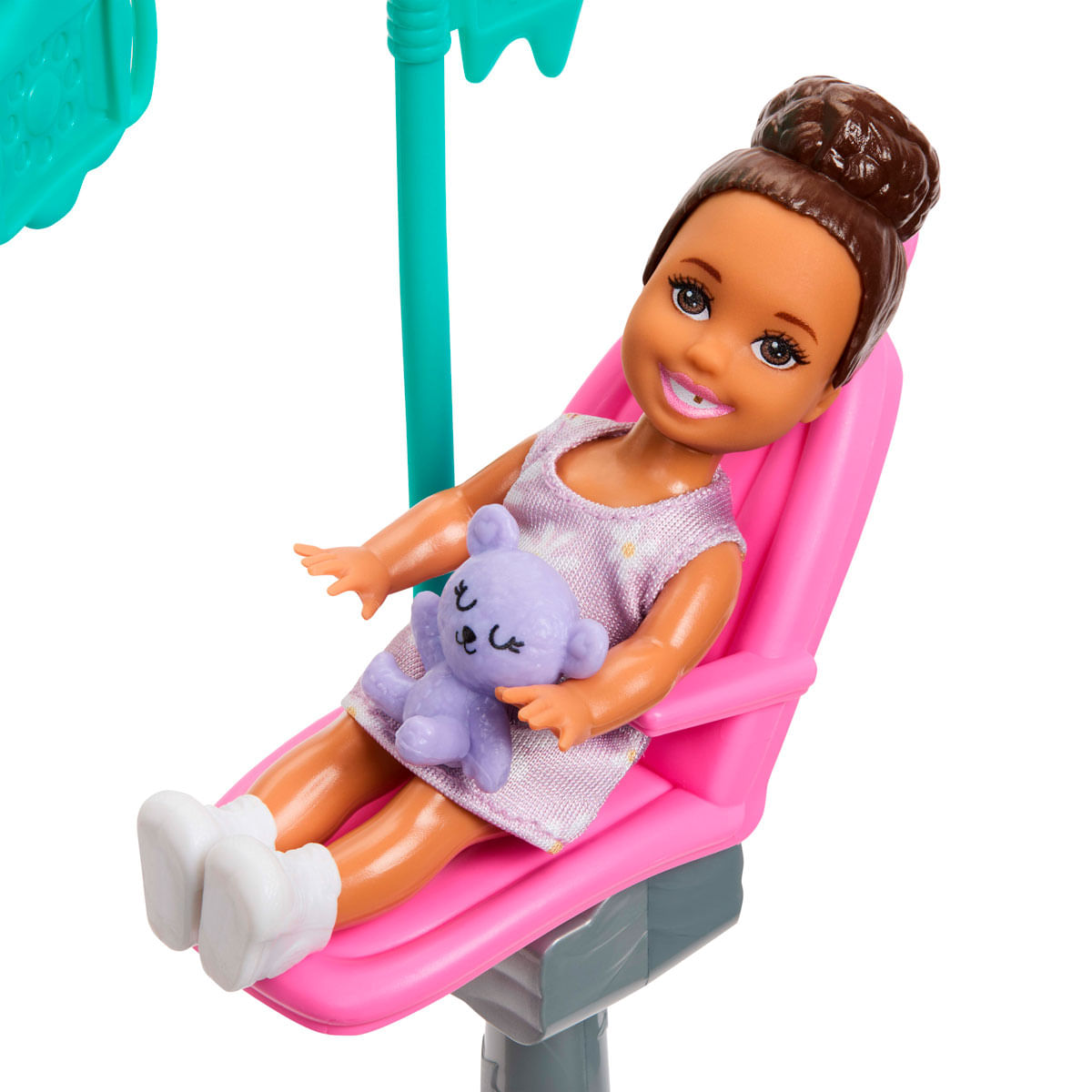 Una niña pequeña se sienta en una silla rosa sosteniendo un osito de peluche morado.