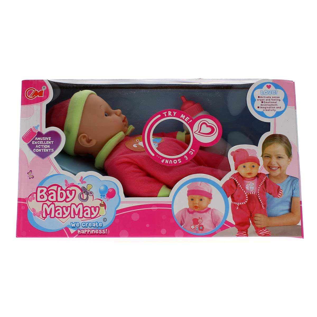 Una muñeca Baby MayMay en una caja rosa, con un atuendo rosa y verde, y una niña sosteniendo otra muñeca a la derecha.