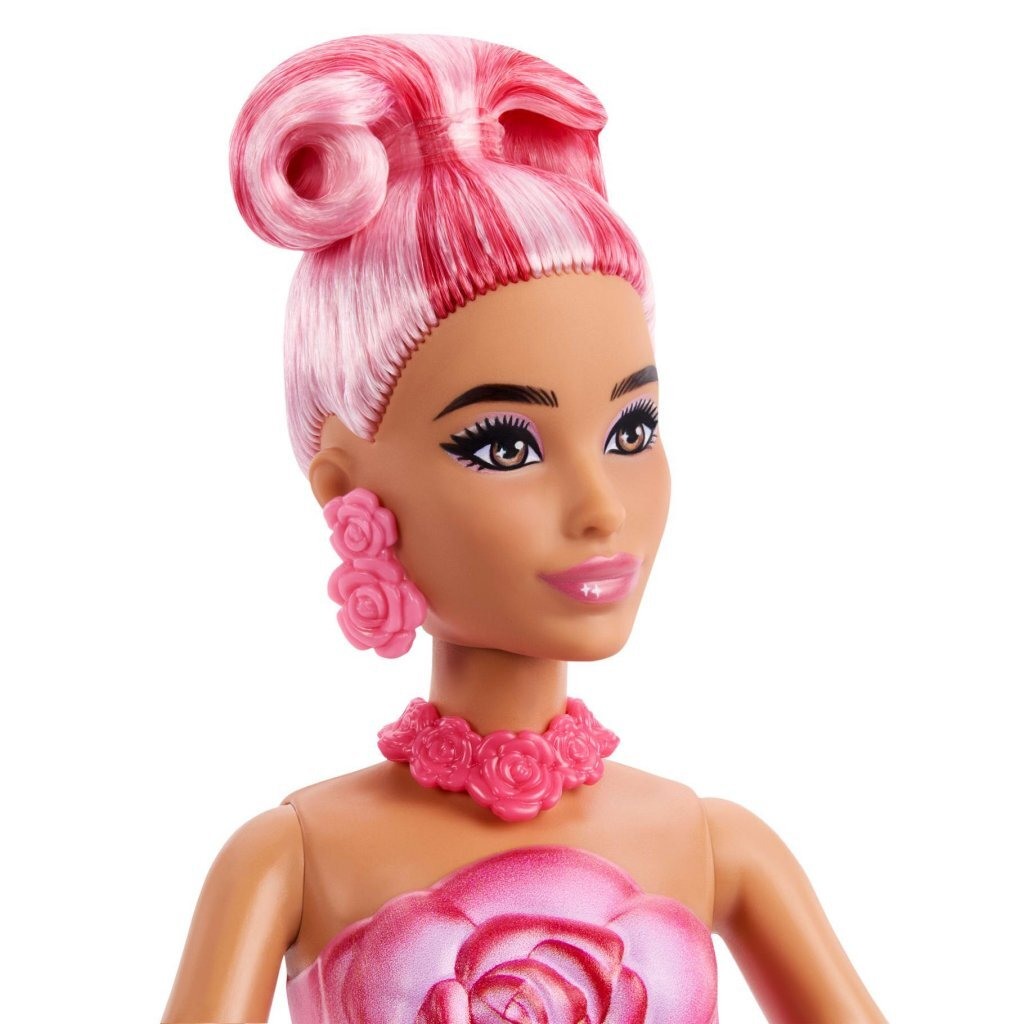 Muñeca Barbie con pelo rosa, pendientes y collar de rosas, fondo blanco.