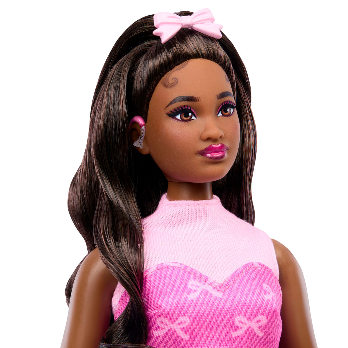 Una muñeca Barbie con cabello castaño, diadema de lazo rosa y vestido rosa.