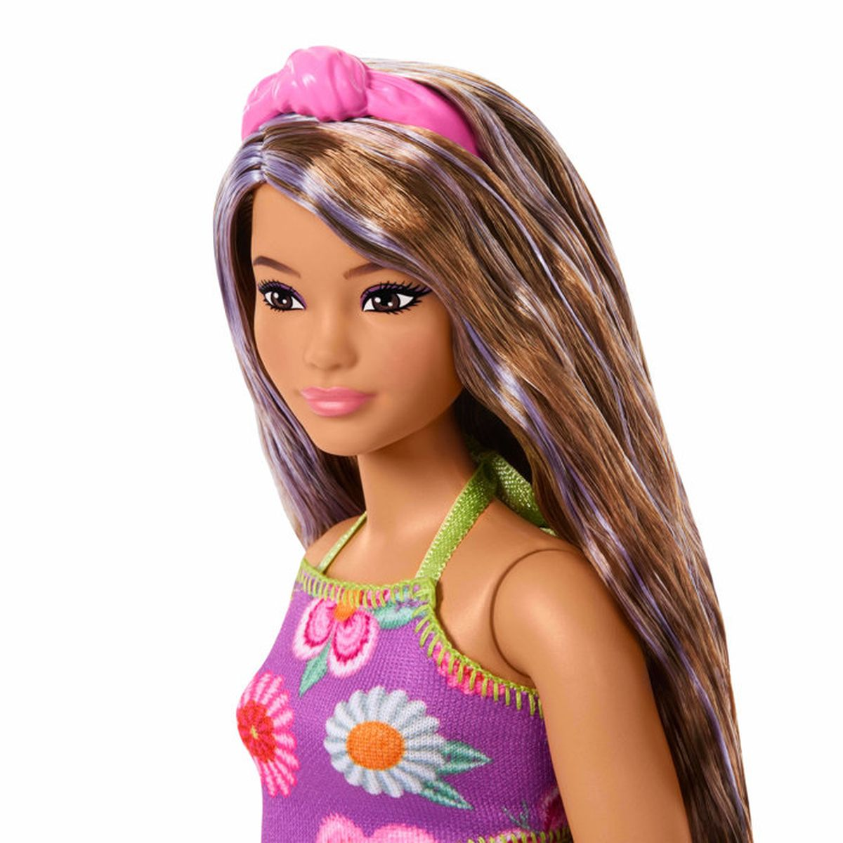 Una muñeca Barbie con pelo castaño, mechones morados, diadema rosa y vestido floral morado.
