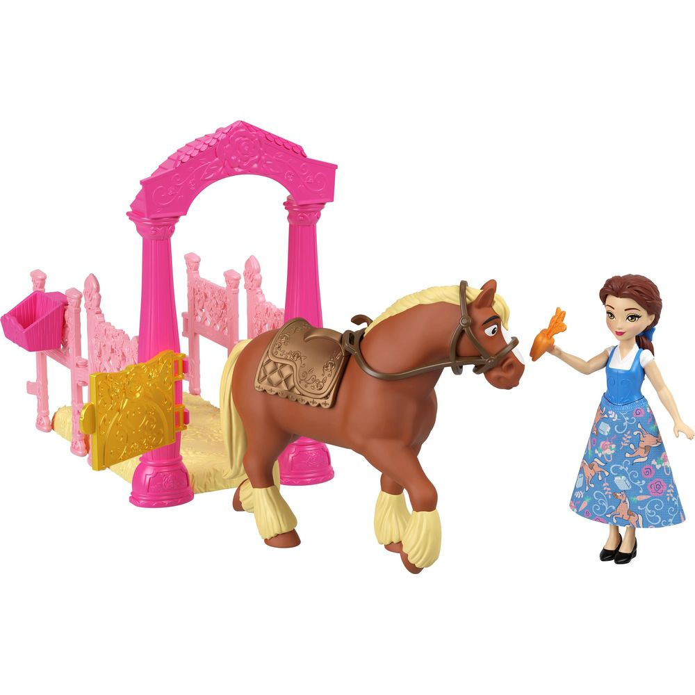 Una muñeca alimenta a un caballo marrón con una zanahoria junto a un establo rosa.