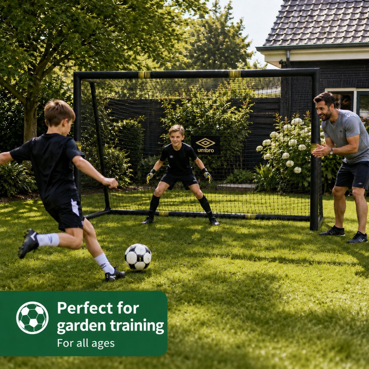 Boys play soccer in the garden. One boy kicks, one guards goal, one man coaches.