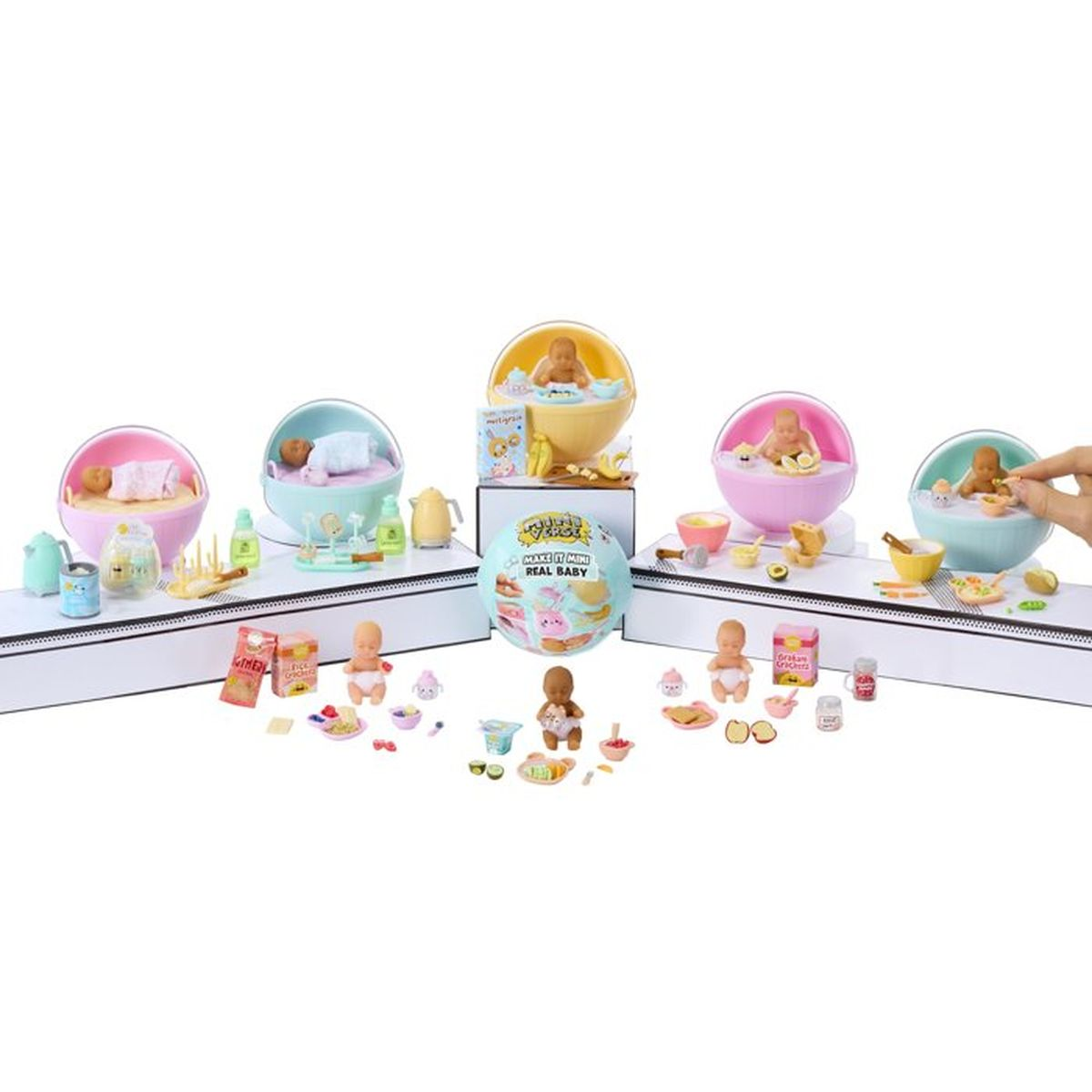 Mini juguetes de bebé en cuencos con accesorios como biberones y comida.