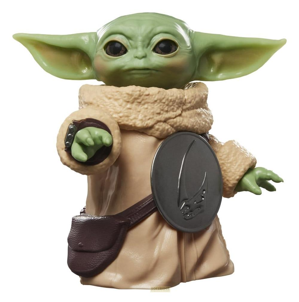 Figura verde con orejas grandes, túnica marrón, bolso y escudo redondo.