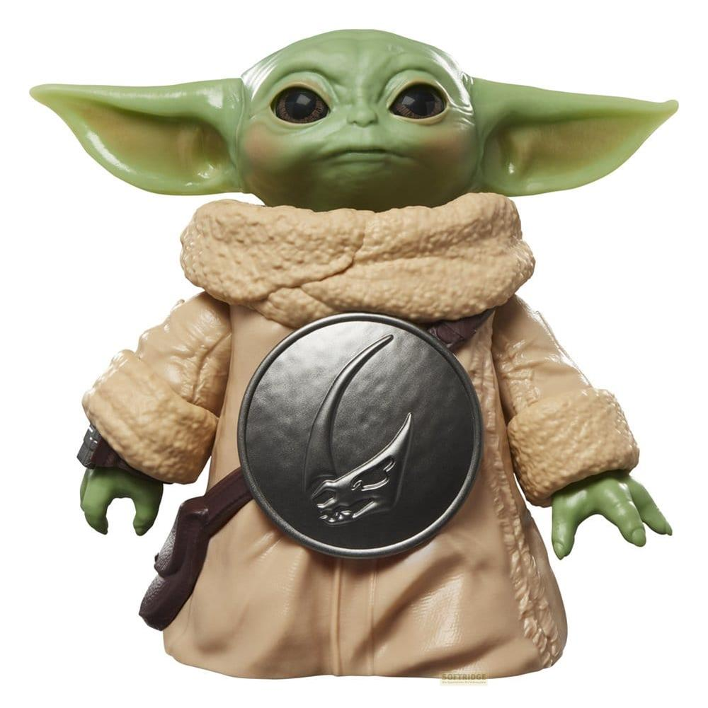 Figura de Baby Yoda con túnica marrón y emblema plateado en el pecho.