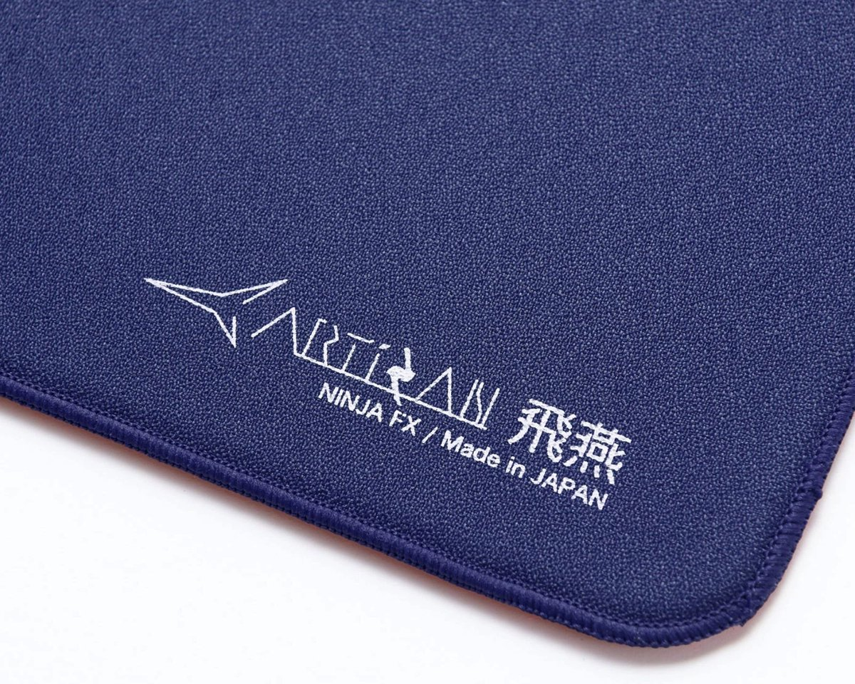 Close-up van een donkerblauw muismat met witte tekst: ARTISAN NINJA FX / Made in JAPAN.