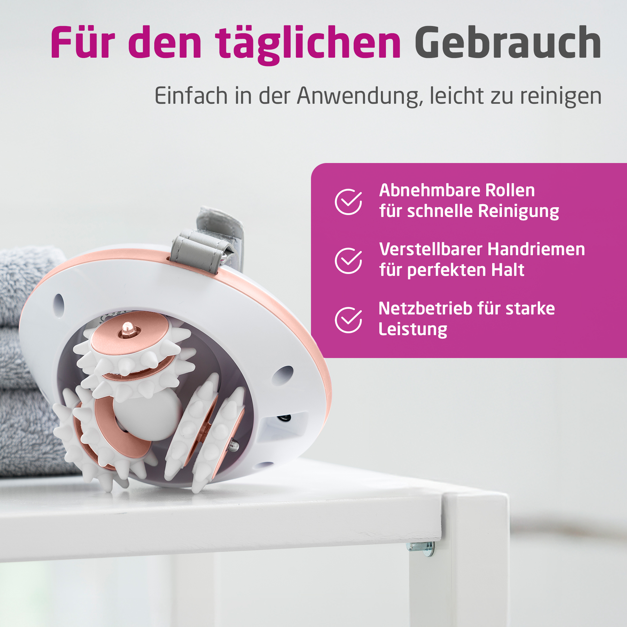Device with rollers, hand strap and power adapter on white shelf, next to towels.