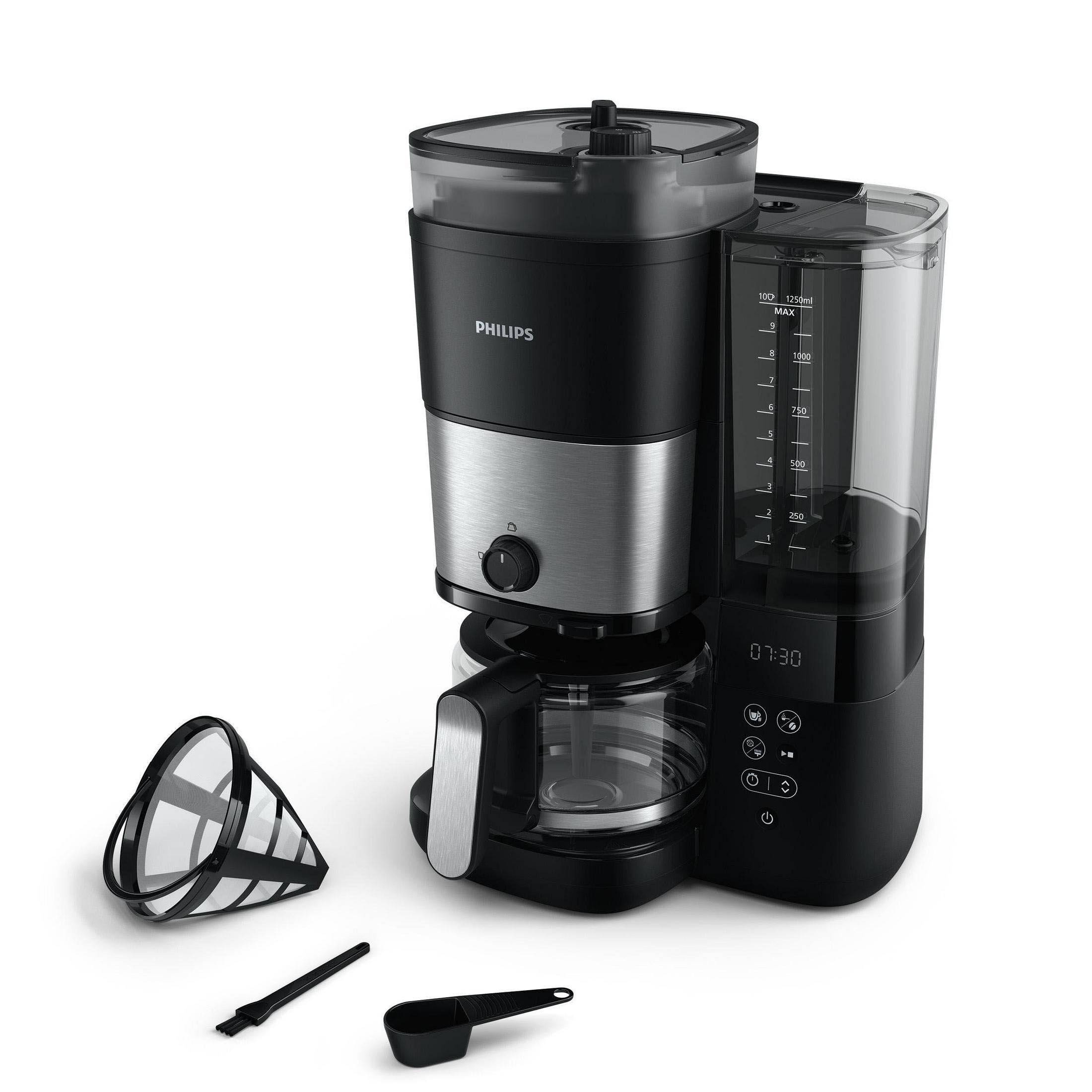 Macchina da caffè Philips nera con caraffa in vetro, misurino, spazzola e portafiltro.