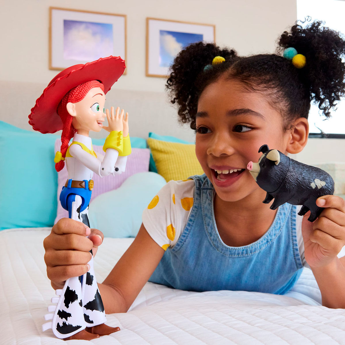 Una niña sostiene figuras de juguete. Una es Jessie, la otra un cerdo.