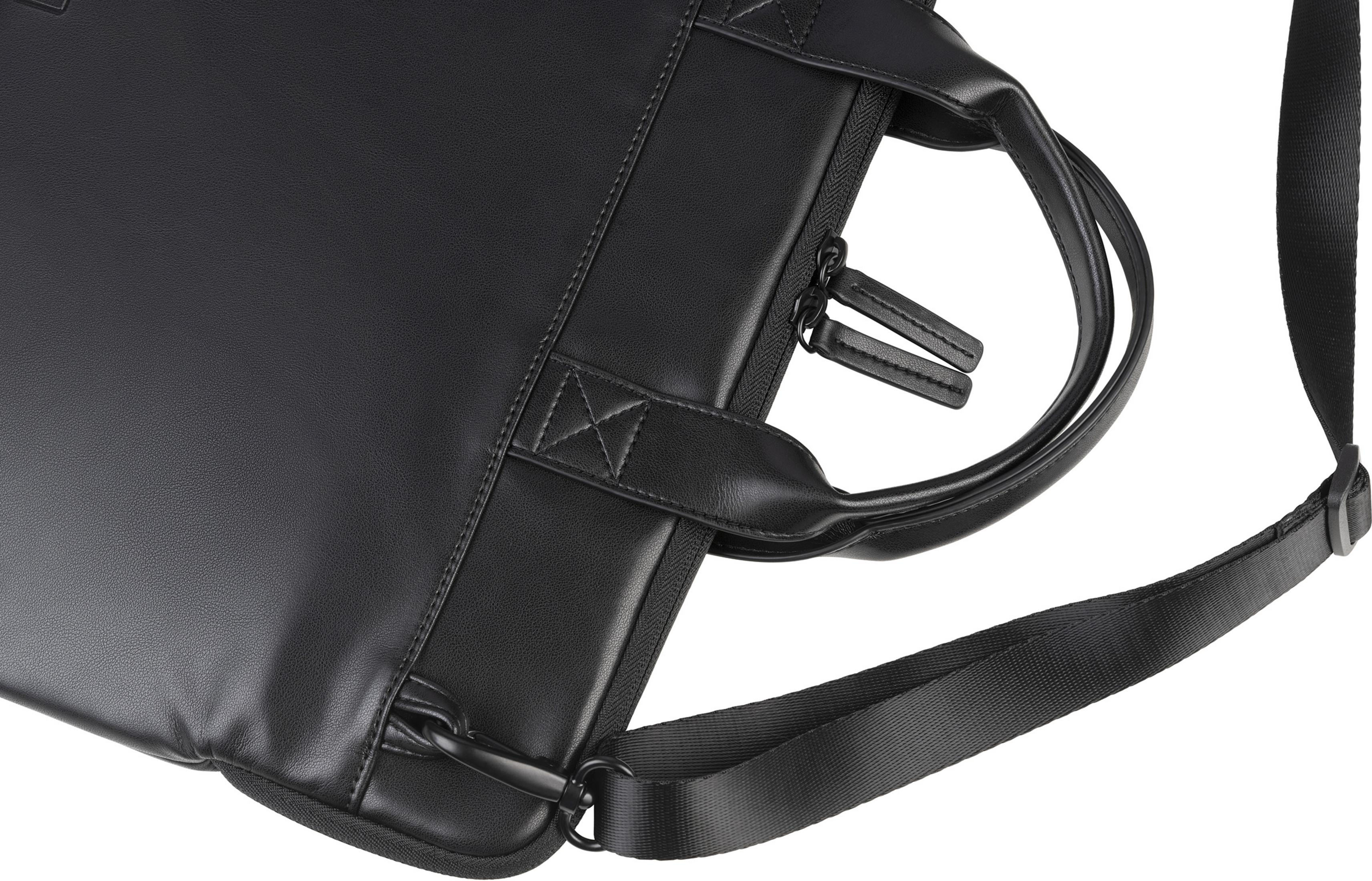 Primo piano di una borsa in pelle nera con cerniere e manico.